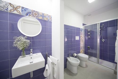 a blue tiled bathroom with a sink and a toilet at B&B Cantiere dell'anima - Rooms of art in Trapani