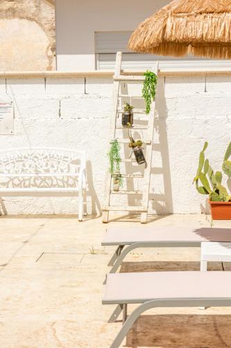 a white bench and a ladder with potted plants at La Gemma del Salento Rooms&Apartments in Racale