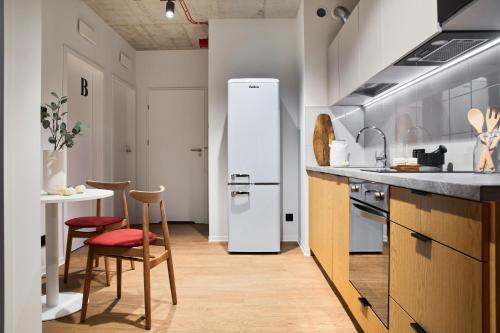 uma cozinha com um frigorífico, uma mesa e cadeiras em Chill Inn em Lódź