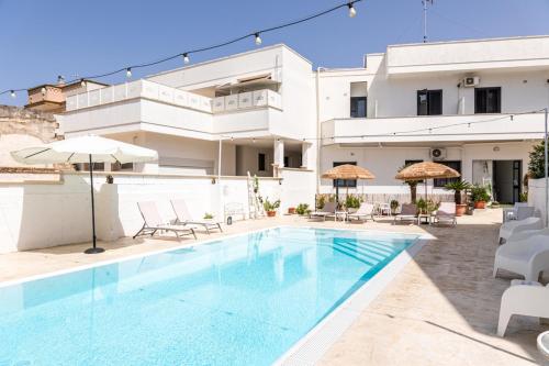 a villa with a swimming pool in front of a building at La Gemma del Salento Rooms&Apartments in Racale