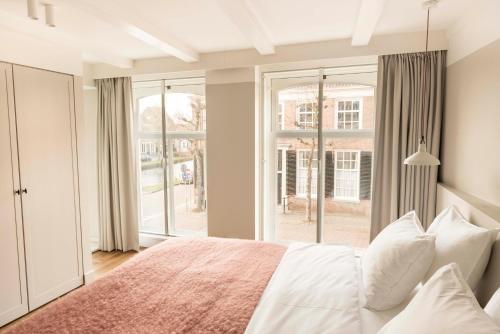 a bedroom with a bed and a large window at Boutique Hotel Weesp in Weesp