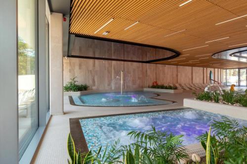 a large swimming pool in a room with a large window at Cristallo Apartament Luxury Resort & SPA - Sea View by Renters Prestige in Międzyzdroje