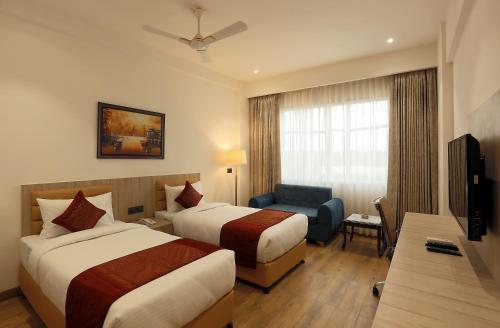 a hotel room with two beds and a television at HOTEL LE SEASONS PARK in Greater Noida