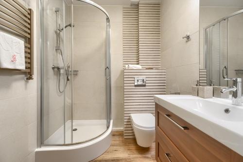 un bagno con doccia, lavandino e WC di Your Holidays Pomorska a Międzyzdroje
