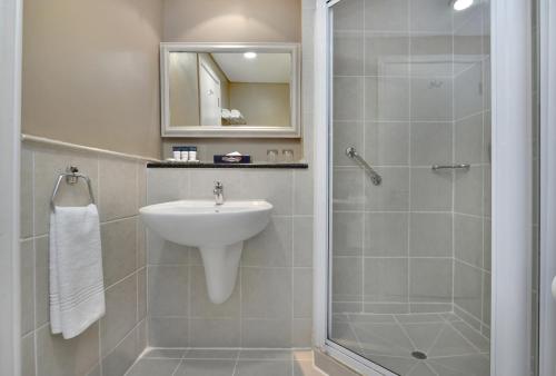 a bathroom with a sink and a shower at Protea Hotel by Marriott Nelspruit in Nelspruit