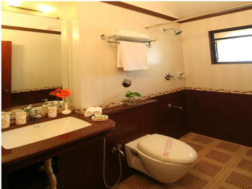 a bathroom with a toilet and a sink at Lambana Resort in Calangute