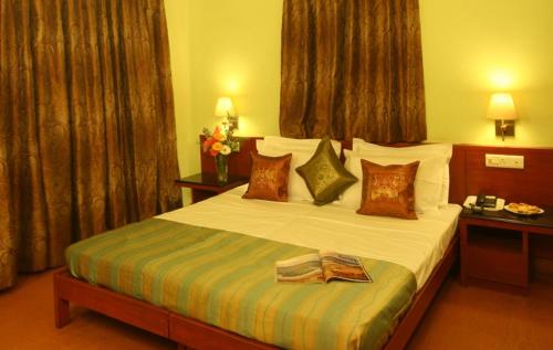 a hotel room with a large bed with pillows at Lambana Resort in Calangute