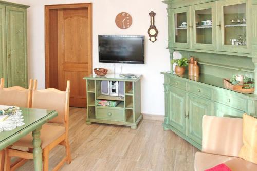 a living room with a television and a green cabinet at Ferienwohnung Sommerwiese in Lübbenau