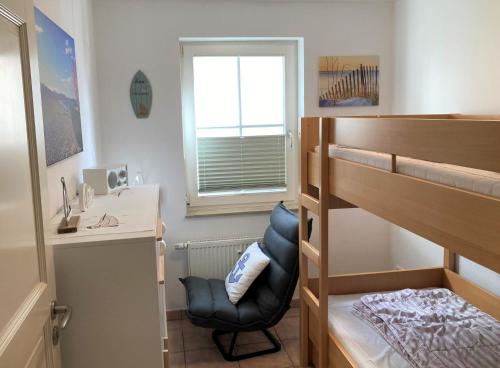 a bedroom with a bunk bed and a desk and a chair at Strandtraum in Glowe