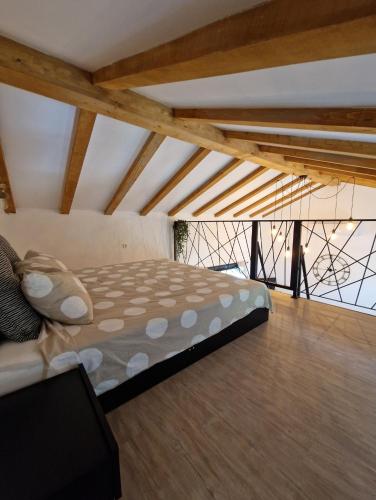 a bedroom with a bed in a room with wooden ceilings at Casa della Noemi in Nedeščina