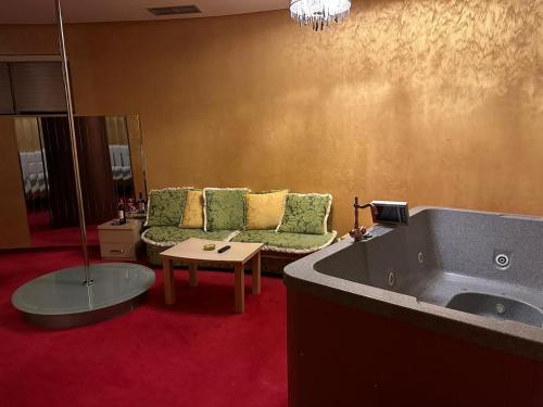 a living room with a couch and a tub at HOTEL GJUTA in Tirana