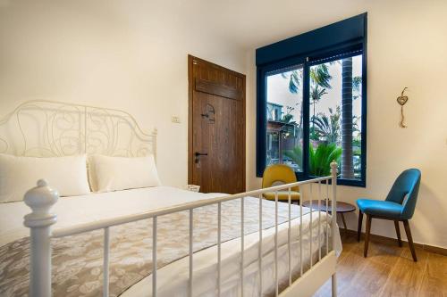 sypialnia z łóżkiem, stołem i oknem w obiekcie Nof glili Mansion w mieście Jawne’el