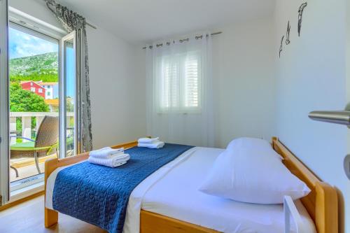 a bedroom with a bed and a large window at Beach Dream Apartments in Ivan Dolac