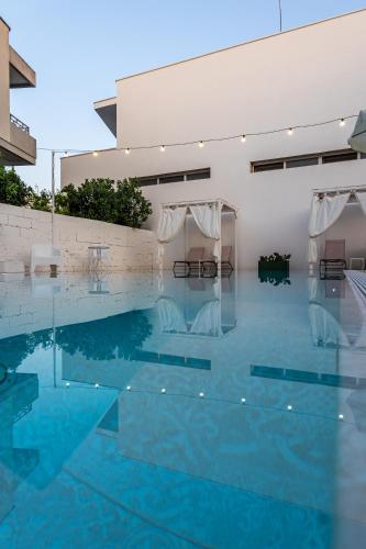a pool with blue water in a building at La Gemma del Salento Rooms&Apartments in Racale