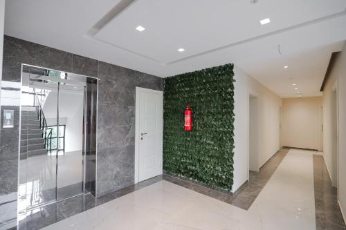 a hallway with a green wall with a red light on it at Hotel Roalb in Vlorë