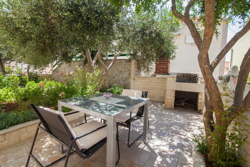 una mesa y sillas en un jardín con un piano en Aurora Apartments, en Bol