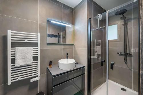 ein Bad mit einem Waschbecken und einer Glasdusche in der Unterkunft Quintessence - Apt B202 - BO Immobilier in Châtel