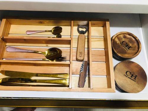 a wooden box filled with different types of utensils at Chic Hideaway at Azure North Bali Tower in San Fernando