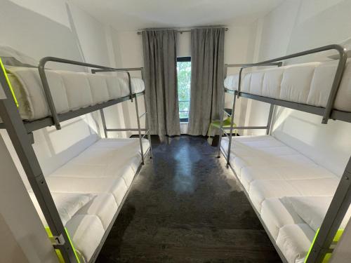 three bunk beds in a room with a window at HI Parque das Nações – Pousada de Juventude in Lisbon