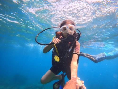 a woman in a scuba diver uniform underwater at Anoo Garden Villa in Trincomalee