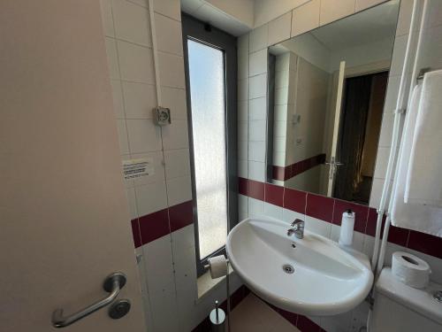 a bathroom with a sink and a mirror at HI Parque das Nações – Pousada de Juventude in Lisbon