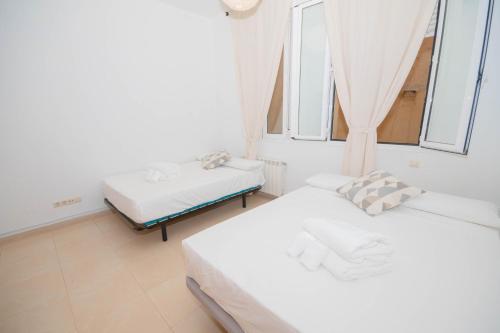 Dos camas en una habitación con dos ventanas. en For You Rentals Hermoso apartamento TEMPORAL Plaza Zerolo - Chueca - Madrid INF1F, en Madrid
