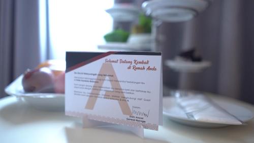 a sign on a table with a plate of food at Aryaduta Makassar in Makassar