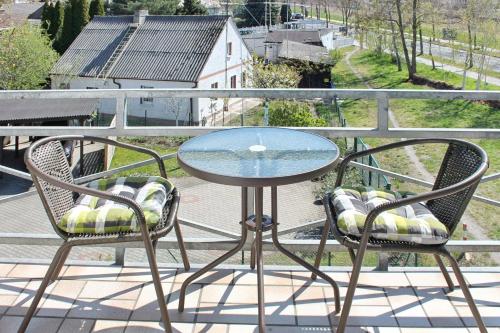 a glass table and two chairs on a balcony at Ferienwohnung Orchidee in Lübbenau