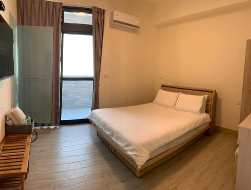 a bedroom with a bed and a large window at Good Days in Yuli