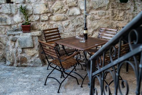 - une table en bois avec 2 chaises et une bouteille de vin dans l'établissement Apartments Leticia, à Split