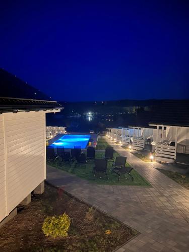 a patio with chairs and a pool at night at Domki M&L in Polańczyk
