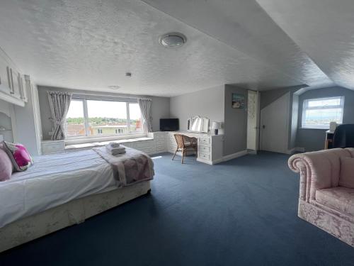 a bedroom with a bed and a chair and a desk at Whitstable house with a view and 2 parking spaces in Kent