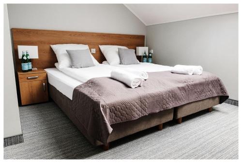 a bedroom with a large bed with two towels on it at Centrum Eventowo- Konferencyjne Pałacyk Fantazja in Sięciaszka Pierwsza