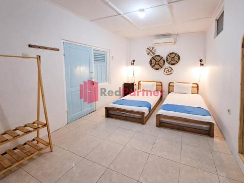 - une chambre avec 2 lits et une fenêtre dans l'établissement Ndalem Ngadiwinatan Homestay Malioboro Yogya RedPartner, à Yogyakarta