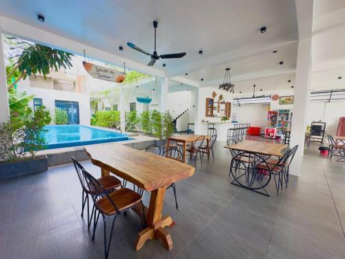 a room with tables and chairs and a pool at Kampot River Bungalow by MAMA in Kampot