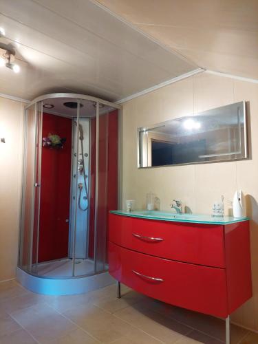 La salle de bains est pourvue d'un lavabo rouge et d'une douche. dans l'établissement Chambre a proximité du circuit des 24 heures, à Guémardières