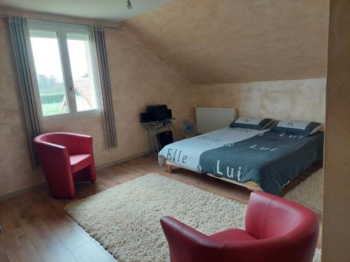 une chambre avec un lit et deux chaises et une fenêtre dans l'établissement Chambre a proximité du circuit des 24 heures, à Guémardières