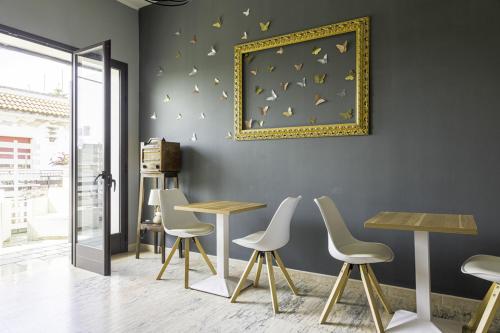a room with tables and chairs and a picture on the wall at La Gemma del Salento Rooms&Apartments in Racale