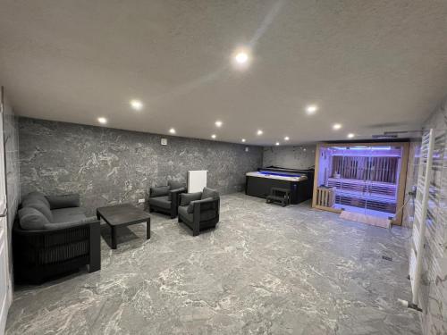 a living room with couches and a large screen tv at Gîte « Les Basse des Grouets » in Blois