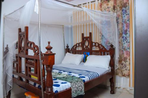 een slaapkamer met een hemelbed bij Serene 2 bedroom homestay 15mindrive to the beach in Mombasa