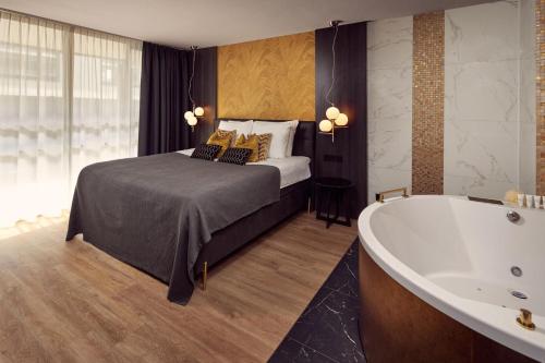 a bedroom with a bed and a bath tub at Van der Valk Hotel Tiel in Tiel