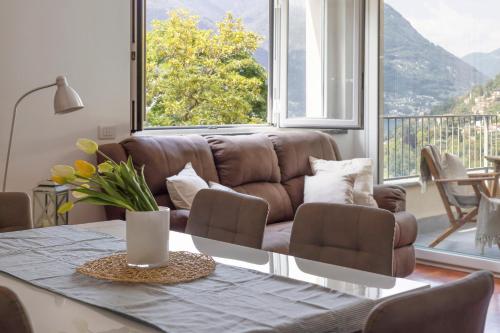 a living room with a brown couch and a table at Appartamento con Terrazzo Vistalago in Blevio