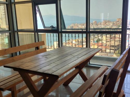 a wooden table in front of a large window at Saranda Boutique Hostel in Sarandë