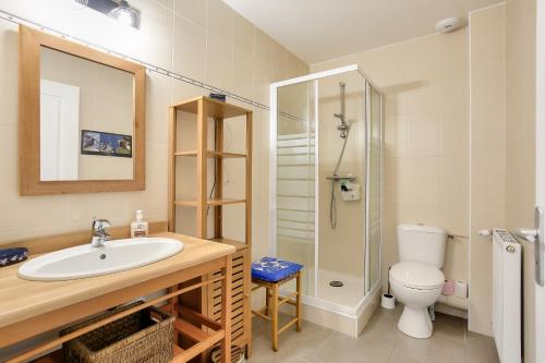 Un baño con lavabo, inodoro y ducha. en Détente et calme sur la Côte d’Émeraude, en Port Blanc