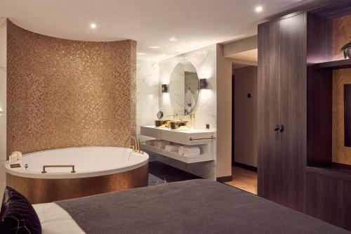 a bathroom with a bath tub and a sink at Van der Valk Hotel Tiel in Tiel