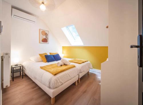 a bedroom with a bed with blue and yellow pillows at Les clés Bélinéenes in Bligny-lès-Beaune