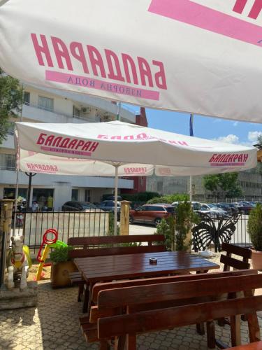 a group of tables and umbrellas in front of a building at Hotel Margarita in Kranevo