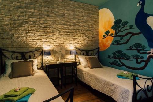 two beds in a room with a brick wall at Villa Tropica, total privacy, tropical garden and private pool in Kaštela