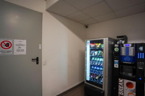 a vending machine in a room with drinks in it at Bnbook Residence Matteotti in Novara