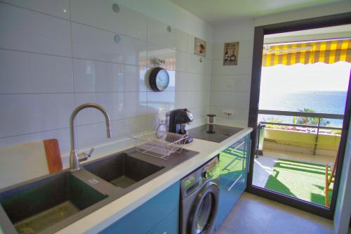 uma cozinha com um lavatório e uma máquina de lavar roupa em Ref EGEE - Palmes d'Or Properties em Cannes